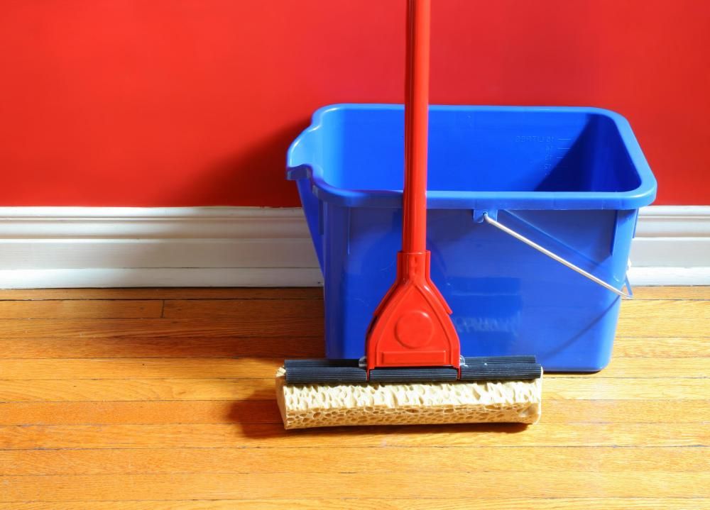 a mop and a basket on hardwood floor.